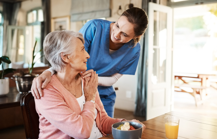 A caregiver helping a senior woman in her Boca Raton home.