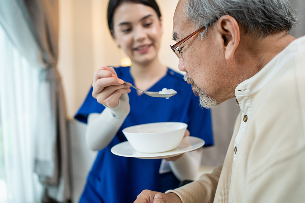 A Seagrape Home Health Care caregiver helping her patient with medication management