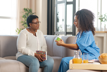 A Seagrape Home Health Care caregiver assisting a senior with eating their meal | Activities Of Daily Living Delray Beach