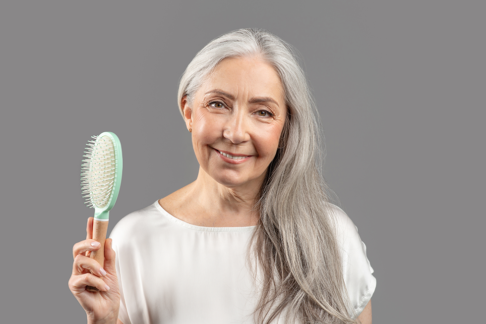 A Boynton Beach senior in her bathroom holding a hairbrush | Bathing and Hygiene Caregiver Delray Beach